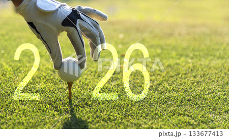 Close up hand Golfer woman putting golf ball for Happy New Year 2026  133677413