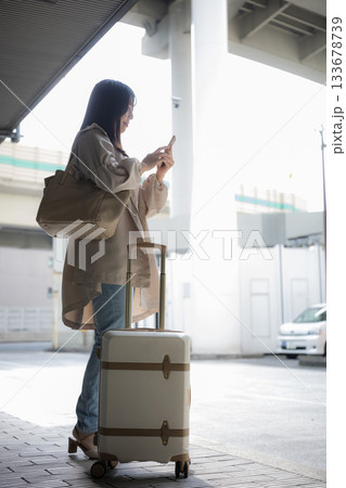空港や交通機関のターミナルででスマホを持つ女性の顔無し写真 旅行や休日のイメージ横顔全身 空港や交通機関のターミナルででスマホを持つ女性の顔無し写真 旅行や休日のイメージ横顔全身 133678739