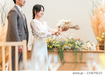 結婚式でチャペル・結婚式場・バージンロードにブーケを持って入場する新郎新婦 133679233