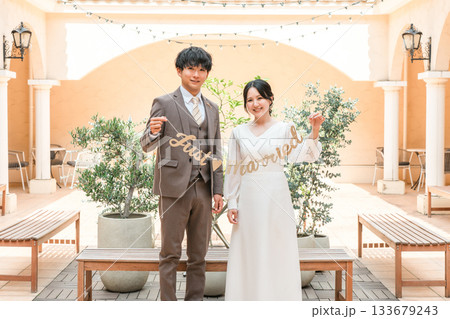 結婚式場でガーランドを持つ新郎新婦（ブライダル・ウェディング） 133679243