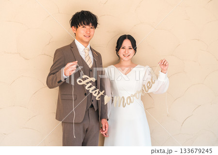 結婚式場でガーランドを持つ新郎新婦（ブライダル・ウェディング） 133679245