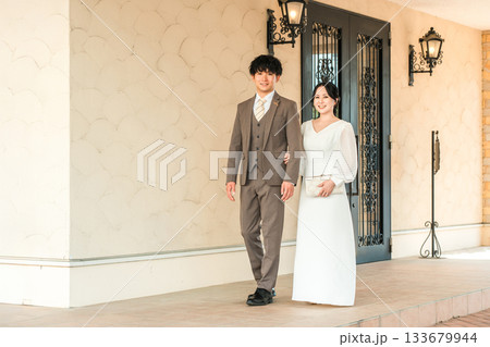 結婚式場を歩く新郎新婦（ウェディング,ディナー,ドレスコード,ブライダル） 133679944
