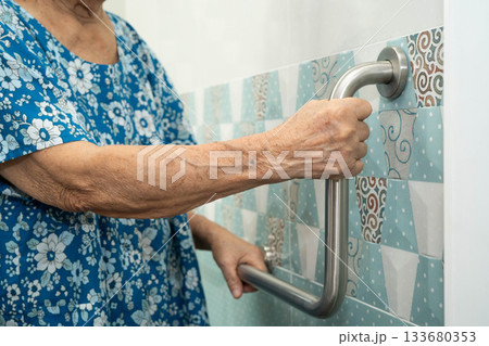 Asian elderly woman use safety handrail in bathroom. Asian elderly woman use safety handrail in bathroom. 133680353