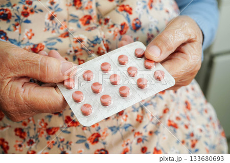 Asian elderly woman holding pill drug in hand, strong healthy medical. 133680693