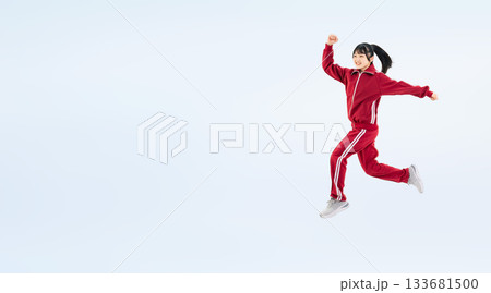 元気にジャンプする体育ジャージを着た女子学生の全身写真 133681500