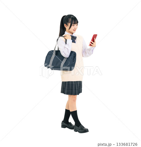 スマホを見ながら歩く制服を着た女子学生　手作業で精密に切り抜いた背景透過全身写真PNG 133681726