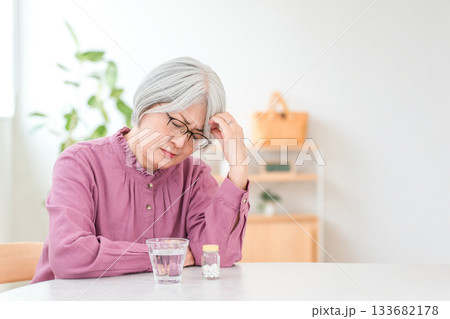 体調不良で頭を抑えるシルバーヘアーのシニア女性 133682178