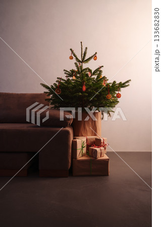 Small christmas tree with natural decorations and gift boxes with warm evening light Small christmas tree with natural decorations and gift boxes with warm evening light 133682830