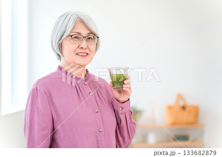 健康のため青汁・グリーンスムージー・野菜ジュースを飲むシニア女性 健康のため青汁・グリーンスムージー・野菜ジュースを飲むシニア女性 133682879