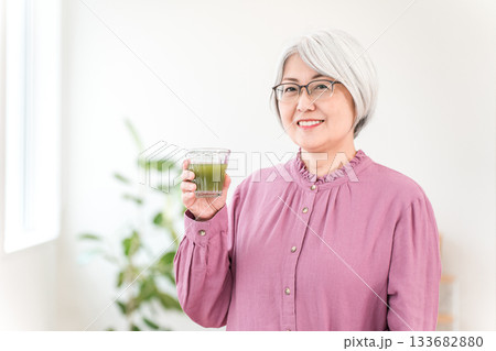健康のため青汁・グリーンスムージー・野菜ジュースを飲むシニア女性 133682880