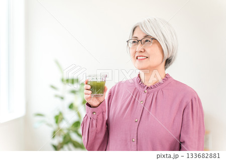 健康のため青汁・グリーンスムージー・野菜ジュースを飲むシニア女性 133682881