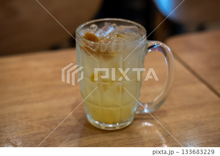 A glass of plum soda, on the wooden table 133683229