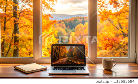 紅葉に染まる秋の森を望む窓際デスクにノートパソコンが置かれた書斎「AI生成画像」 133683694