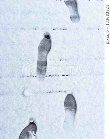 Footprints on fresh untouched snow, top-down view of winter steps on a white frozen surface, symbolizing walking, solitude, travel and the quiet atmosphere of cold weather landscapes Footprints on fresh untouched snow, top-down view of winter steps on a white frozen surface, symbolizing walking, solitude, travel and the quiet atmosphere of cold weather landscapes 133683821