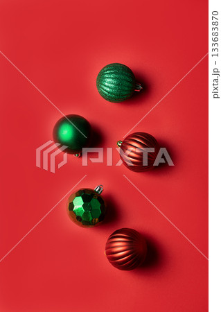 Vertical photo of red and green Christmas balls on red background 133683870
