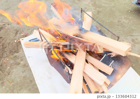 焚き火台で燃える薪の炎と煙 133684312