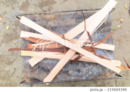 焚き火台に組まれた薪と火起こし準備のアウトドアシーン 133684396
