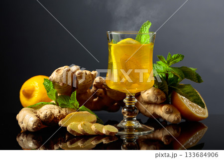 Ginger tea with lemon and mint on a black background. Ginger tea with lemon and mint on a black background. 133684906
