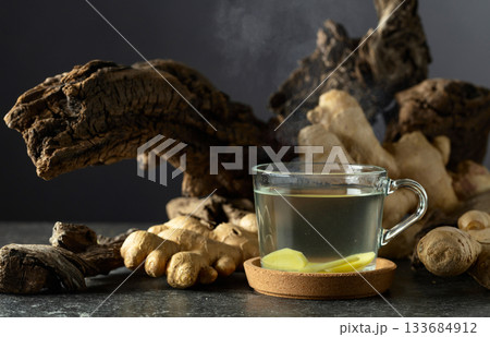 Ginger tea with old snags on a black background. 133684912