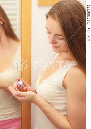Woman taking care of her long hair applying cosmetic oil 133686377