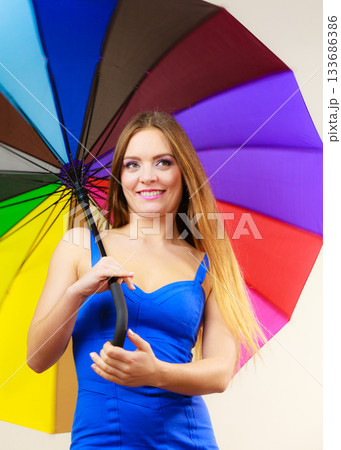 Woman in summer dress holds colorful umbrella Woman in summer dress holds colorful umbrella 133686386