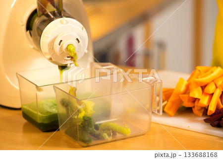 Make vegetables juice in juicer machine 133688168