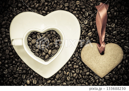 Heart shaped cup and cookie on coffee beans background Heart shaped cup and cookie on coffee beans background 133688230