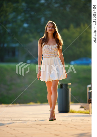 Slavic Woman Walking in Sunlit Urban Park Slavic Woman Walking in Sunlit Urban Park 133688484