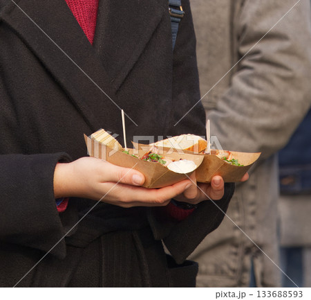 Hands Holding Street Food Portions at a Farmers Market Hands Holding Street Food Portions at a Farmers Market 133688593