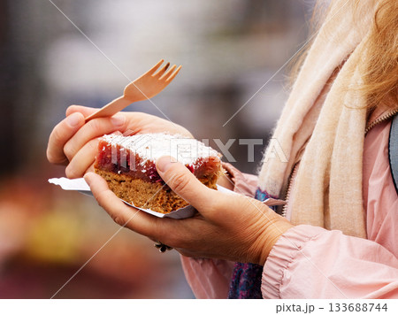 Woman enjoying fruit dessert at Prague farmers market Woman enjoying fruit dessert at Prague farmers market 133688744