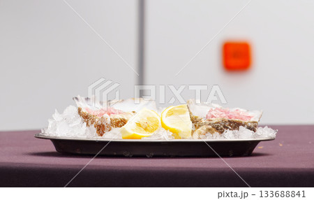 Fresh oysters on ice with lemon slices Fresh oysters on ice with lemon slices 133688841