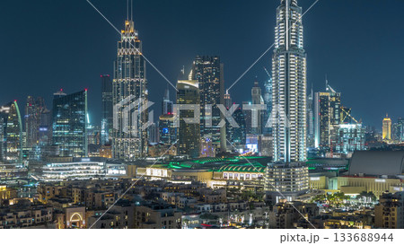 Aerial nighttime cityscape with illuminated architecture of Dubai downtown timelapse, United Arab Emirates. 133688944