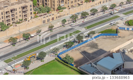 Excavator, truck and grader working at road construction site in Dubai downtown timelapse 133688963