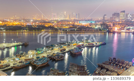Dubai creek landscape day to night timelapse with boats and ship near waterfront 133689379
