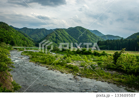 福島県南会津町・伊南川と緑豊かな山並みの初夏の風景 福島県南会津町・伊南川と緑豊かな山並みの初夏の風景 133689507