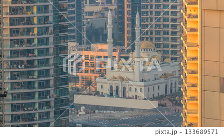 Al Raheem mosque between skyscrapers timelapse on the marina walk in Dubai Marina, Dubai, UAE. 133689571