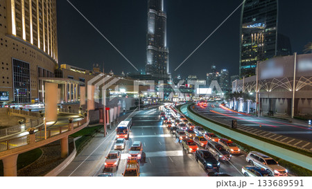 Car traffic on road near mall at night in downtown timelapse hyperlapse. 133689591