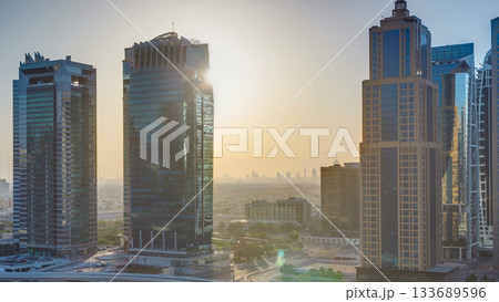 Aerial view of Jumeirah lakes towers skyscrapers at sunrise timelapse with traffic on sheikh zayed road. 133689596