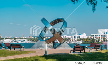 Ring monument, bench, green lawn, flowers and trees at Dubai Creek park timelapse. Dubai, United Arab Emirates Ring monument, bench, green lawn, flowers and trees at Dubai Creek park timelapse. Dubai, United Arab Emirates 133689852