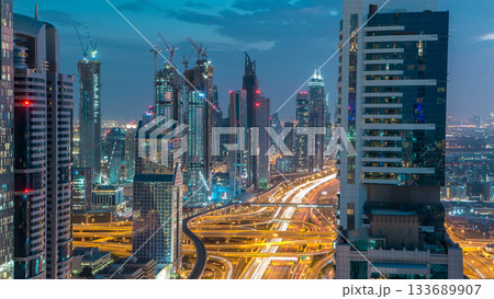Dubai downtown architecture day to night timelapse. Top view over Sheikh Zayed road with illuminated skyscrapers and traffic. 133689907
