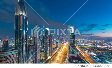 Dubai downtown architecture day to night timelapse. Top view over Sheikh Zayed road with illuminated skyscrapers and traffic. 133689909