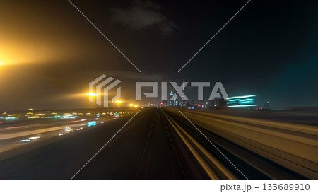 Front cabin POV view from modern driver-less metro train rush forward, along night Dubai, smooth timelapse. Front cabin POV view from modern driver-less metro train rush forward, along night Dubai, smooth timelapse. 133689910