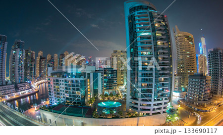 Dubai Marina at night timelapse with light trails of boats on the water and cars, Dubai, UAE 133690117