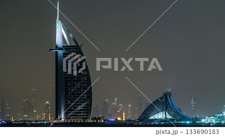 Skyline of Dubai at night timelapse with Burj al Arab in foreground in Dubai, United Arab Emirates 133690183