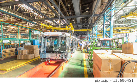 Conveyor assembly stage the body of tractor at big industrial factory timelapse 133690451