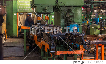 Conveyor assembly stage the body of tractor at big industrial factory timelapse Conveyor assembly stage the body of tractor at big industrial factory timelapse 133690453