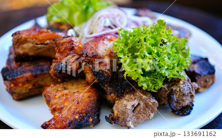 Spicy hot grilled spare pork ribs. Barbecue meat. Black background. Top view 133691162
