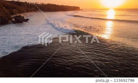 Surfers on Padang Padang on evening at sunset with perfect waves Surfers on Padang Padang on evening at sunset with perfect waves 133692796