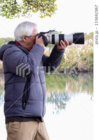 カメラを構えるシニア男性_タテ位置 133692967