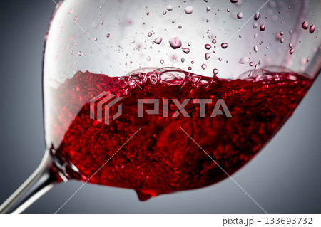 Red wine is poured into a glass. Red wine is poured into a glass. 133693732